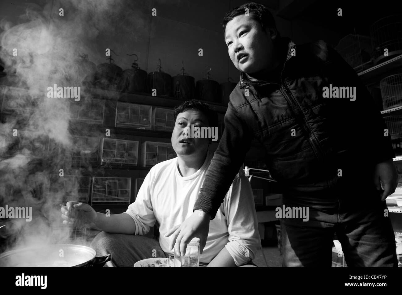 Gaobeidian, Pechino. Gli uomini avente una hotpot pranzo con gli amici in un negozio di uccelli. Foto Stock