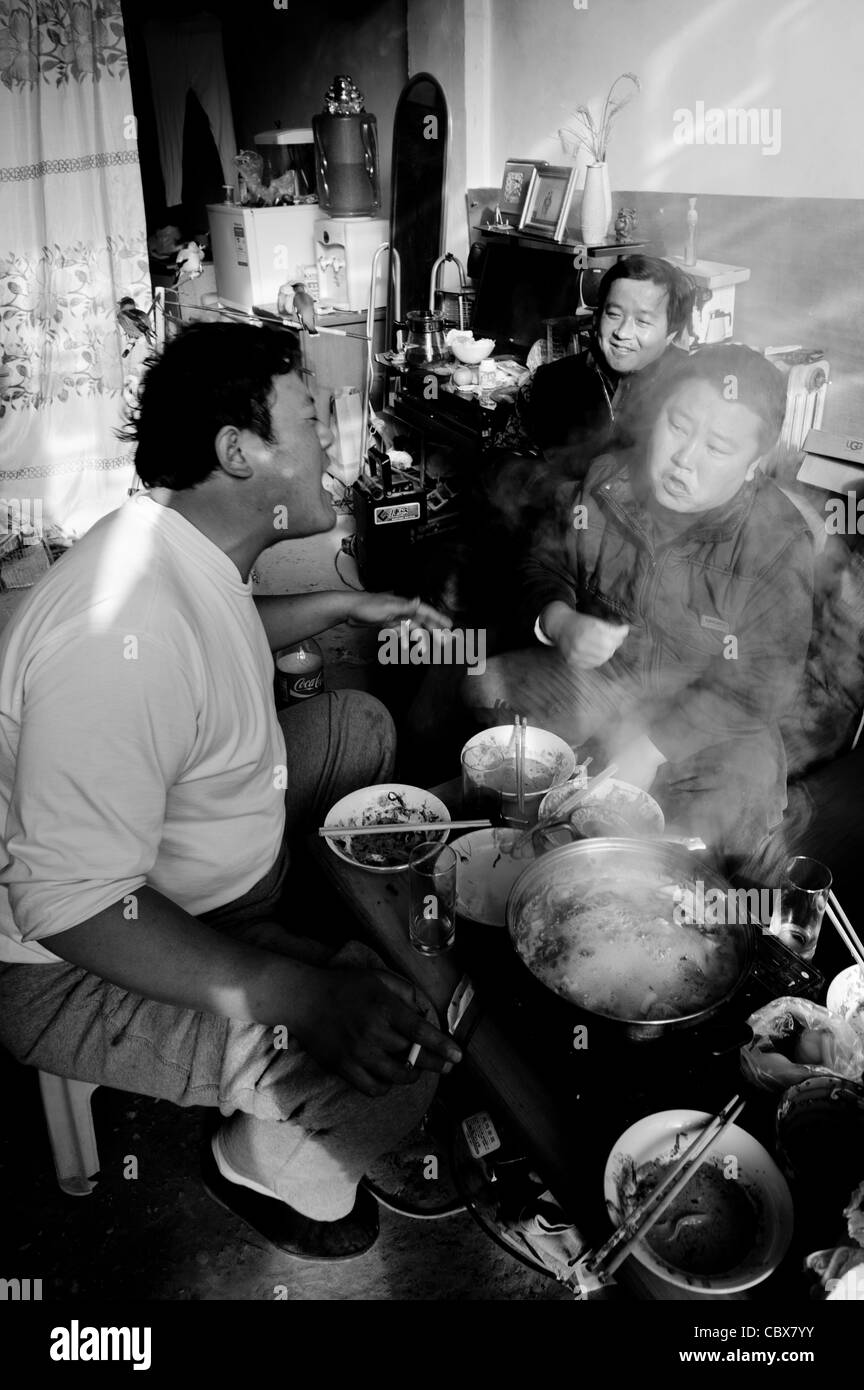 Gaobeidian, Pechino. Gli uomini avente una hotpot pranzo e bevande con gli amici in un negozio di uccelli. Foto Stock