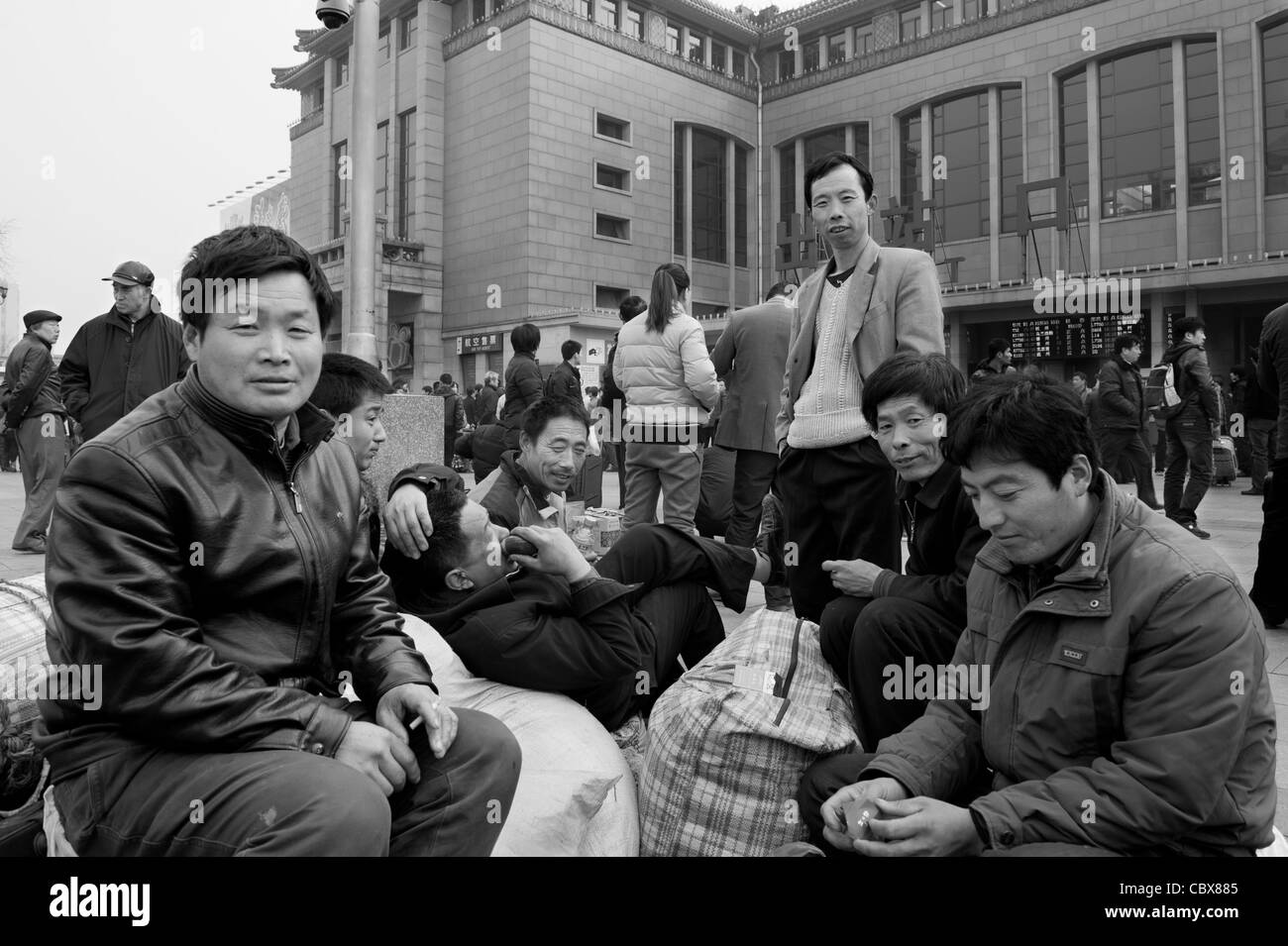 Pechino. I lavoratori migranti in attesa di un treno nella piazza di fronte alla Stazione Ferroviaria di Pechino. Foto Stock