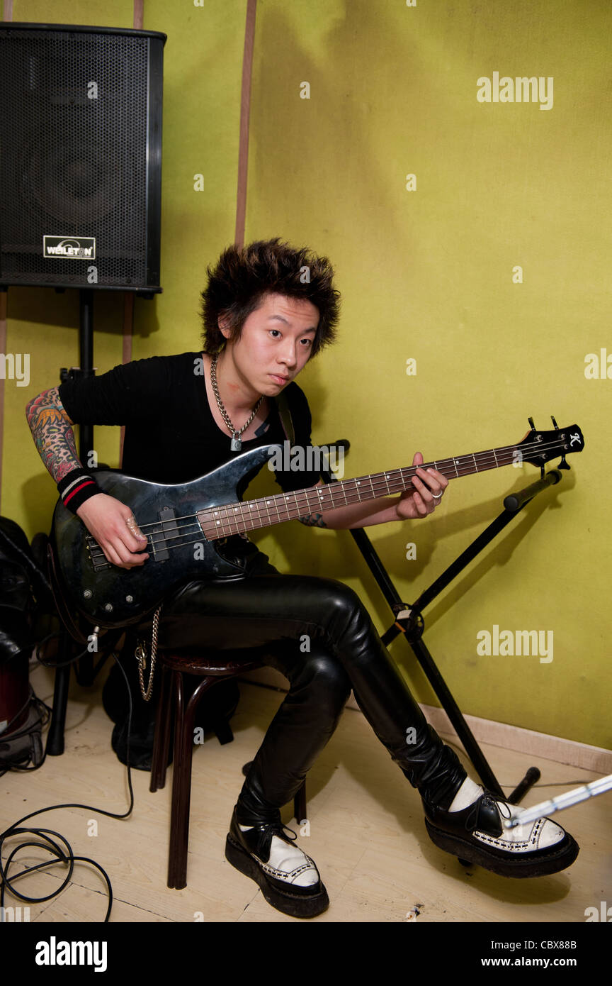 Pechino. Qian Han a suonare il basso durante una prova della street band punk "perché". Foto Stock