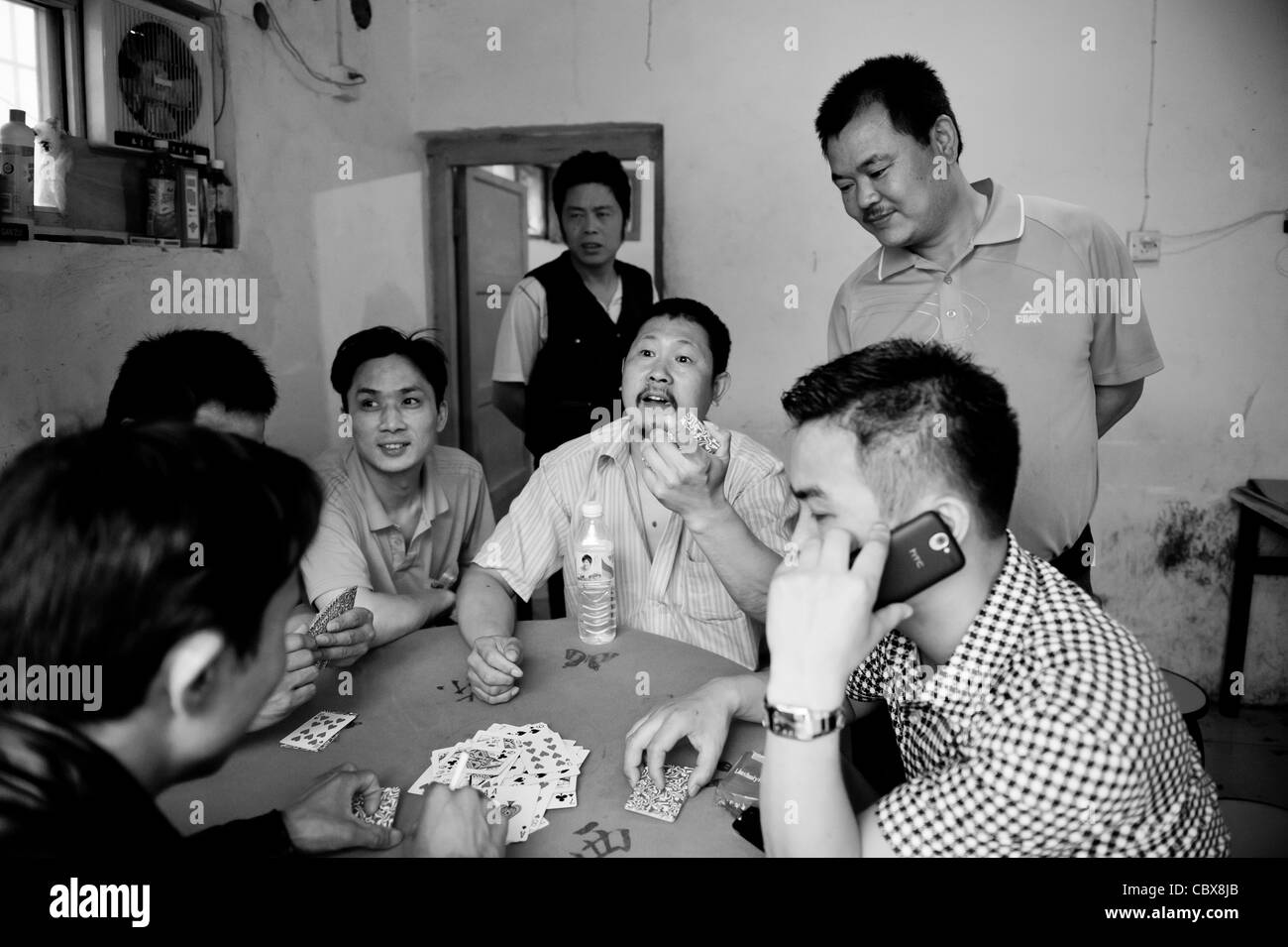 Pechino, vicino Dongfeng park. L'uomo gioca un serio gioco di carte con high stakes. Foto Stock