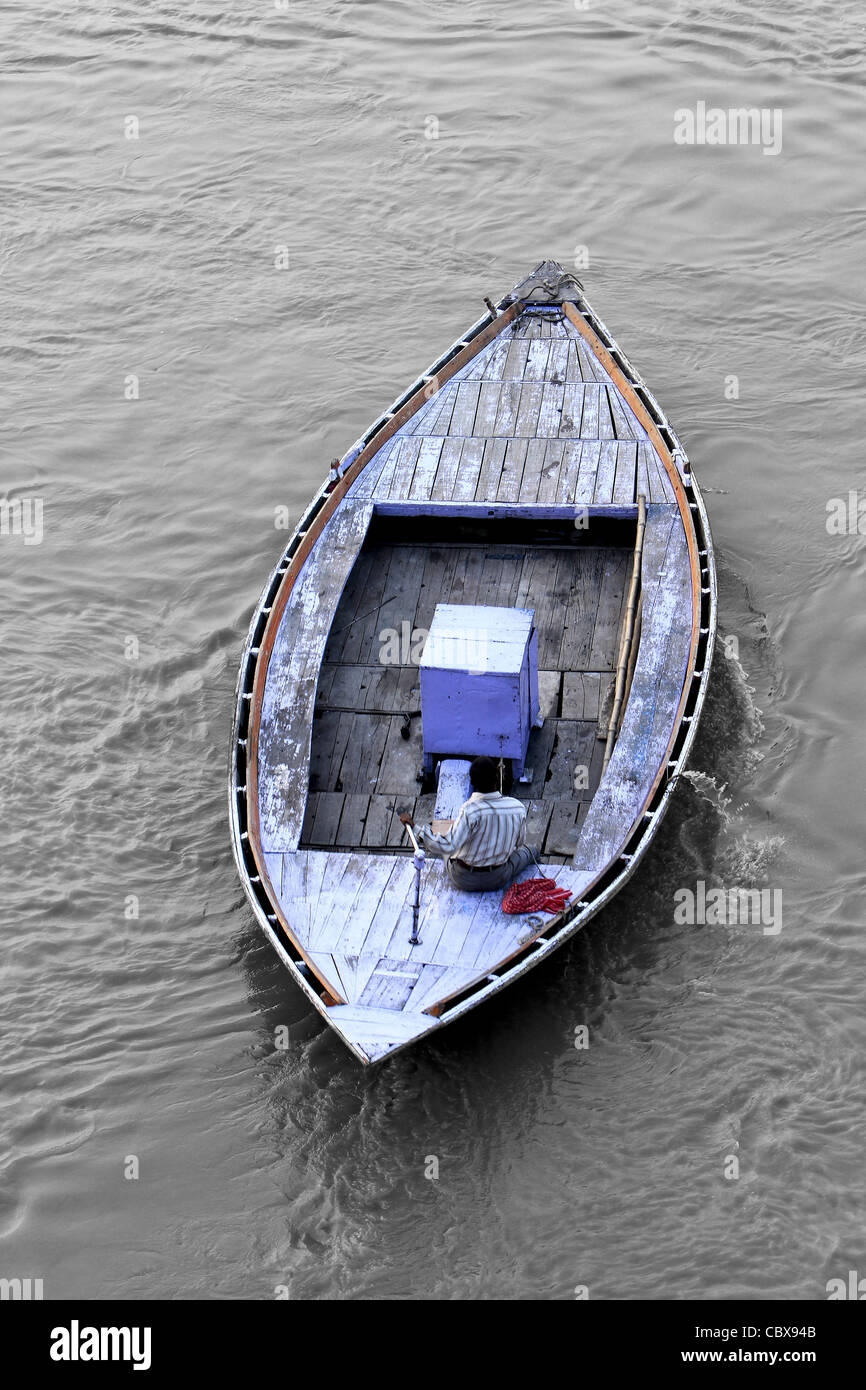 Uomo sulla barca di legno tradizionale sul fiume Gange. India Foto Stock