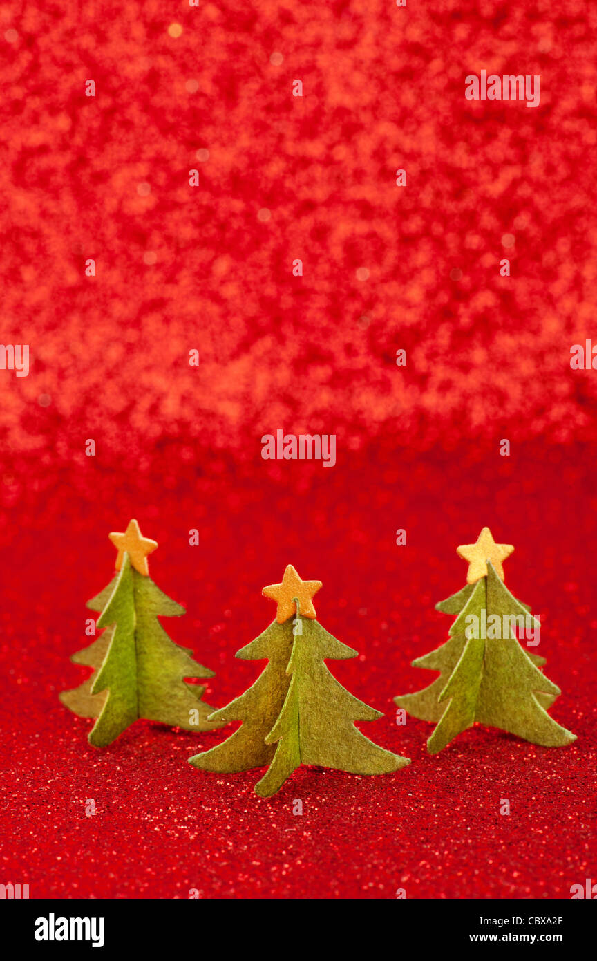 3 libro verde di alberi di Natale con stelle dorate su cime, oltre rosso sfondo glitter Foto Stock