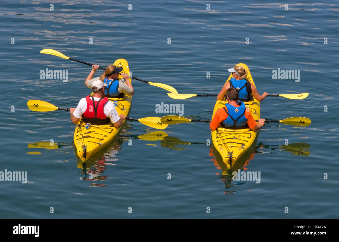 Kayakers, Bar Harbor, Maine. Un gruppo di studenti in giubbotti di salvataggio provare a sguazzare in acque tranquille del porto. Foto Stock