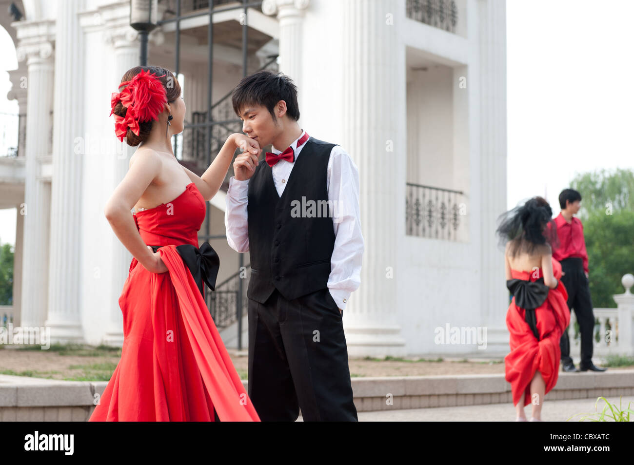 Beijing Chaoyang Park. Lavoratore che trasportano rifiuti passando un wedding photo shoot. Foto Stock