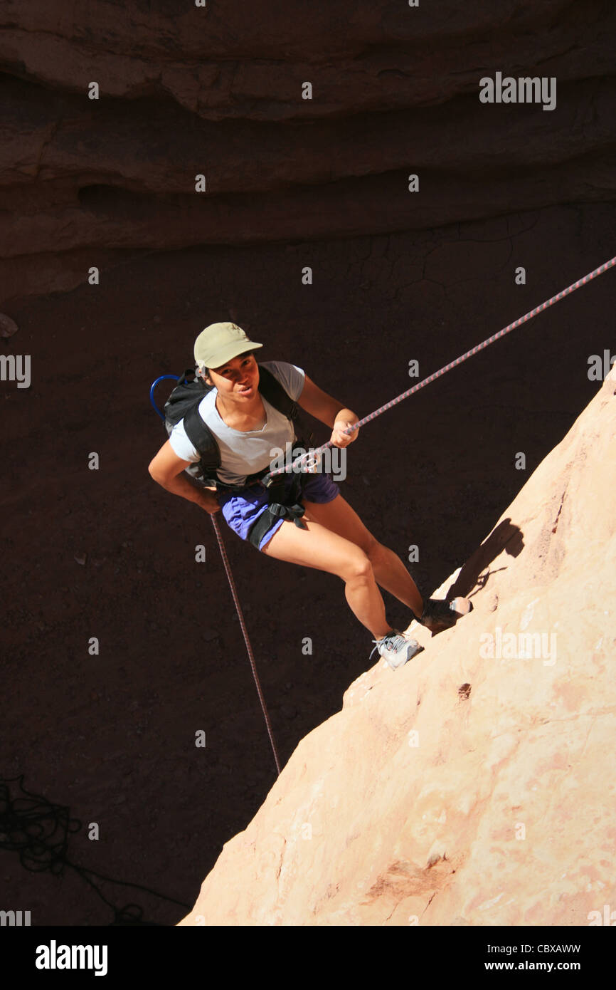 Canyoning donna asiatica rappels in un canyon nascosto in basso Foto Stock