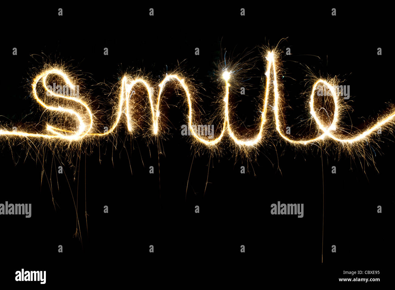 SMILE scritto con un sparkler di notte Foto Stock