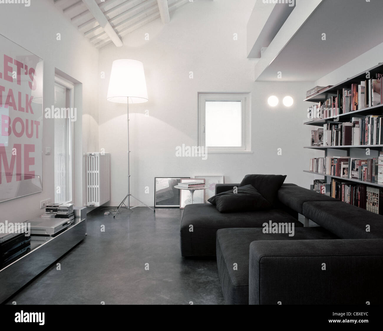 Soggiorno moderno lettino in mansarda con tessuto grigio e pavimento in resina Foto Stock
