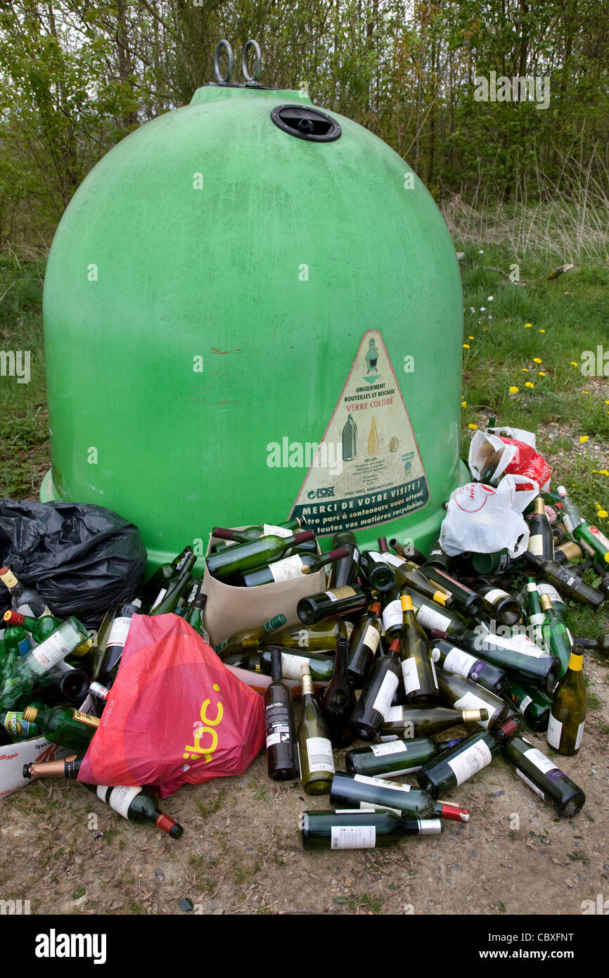 Il vetro del punto di raccolta / Bottle Bank con oggetto di dumping le bottiglie di vino nella parte anteriore Foto Stock