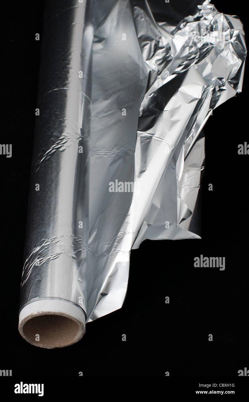Cuocere un foglio di alluminio su sfondo nero Foto Stock