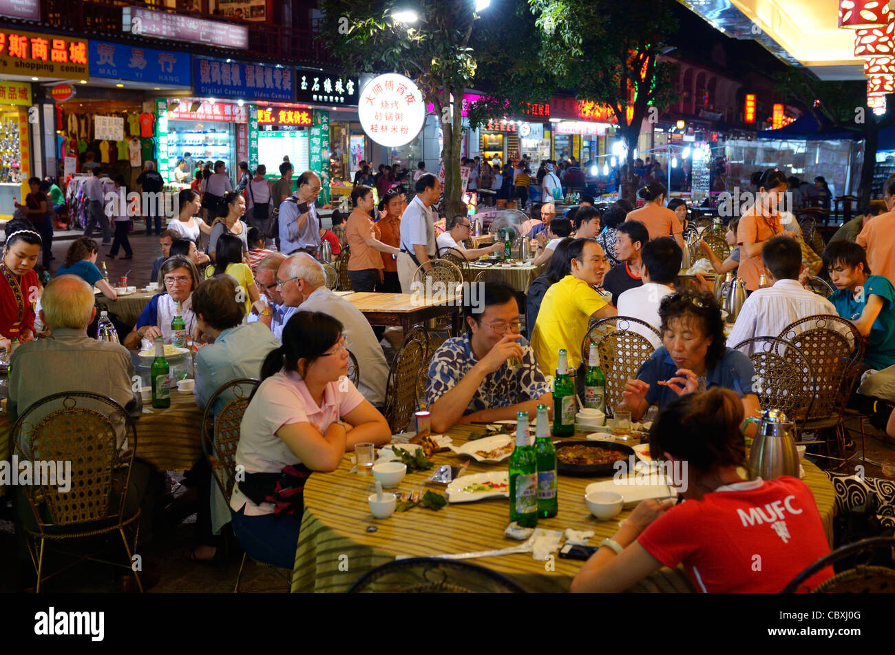 Il popolo cinese di mangiare al fresco presso outdoor street ristorante di notte in yangshuo cina Foto Stock