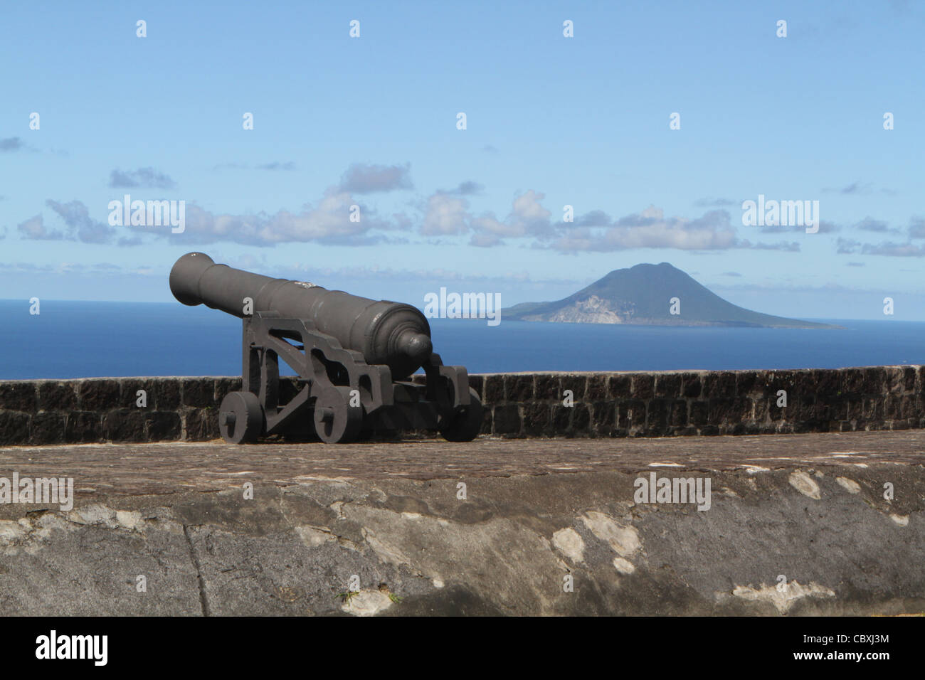 Brimstone Hill Fortress che mostra un muso a cannone di carico con l'isola di St Eustatius a distanza Foto Stock