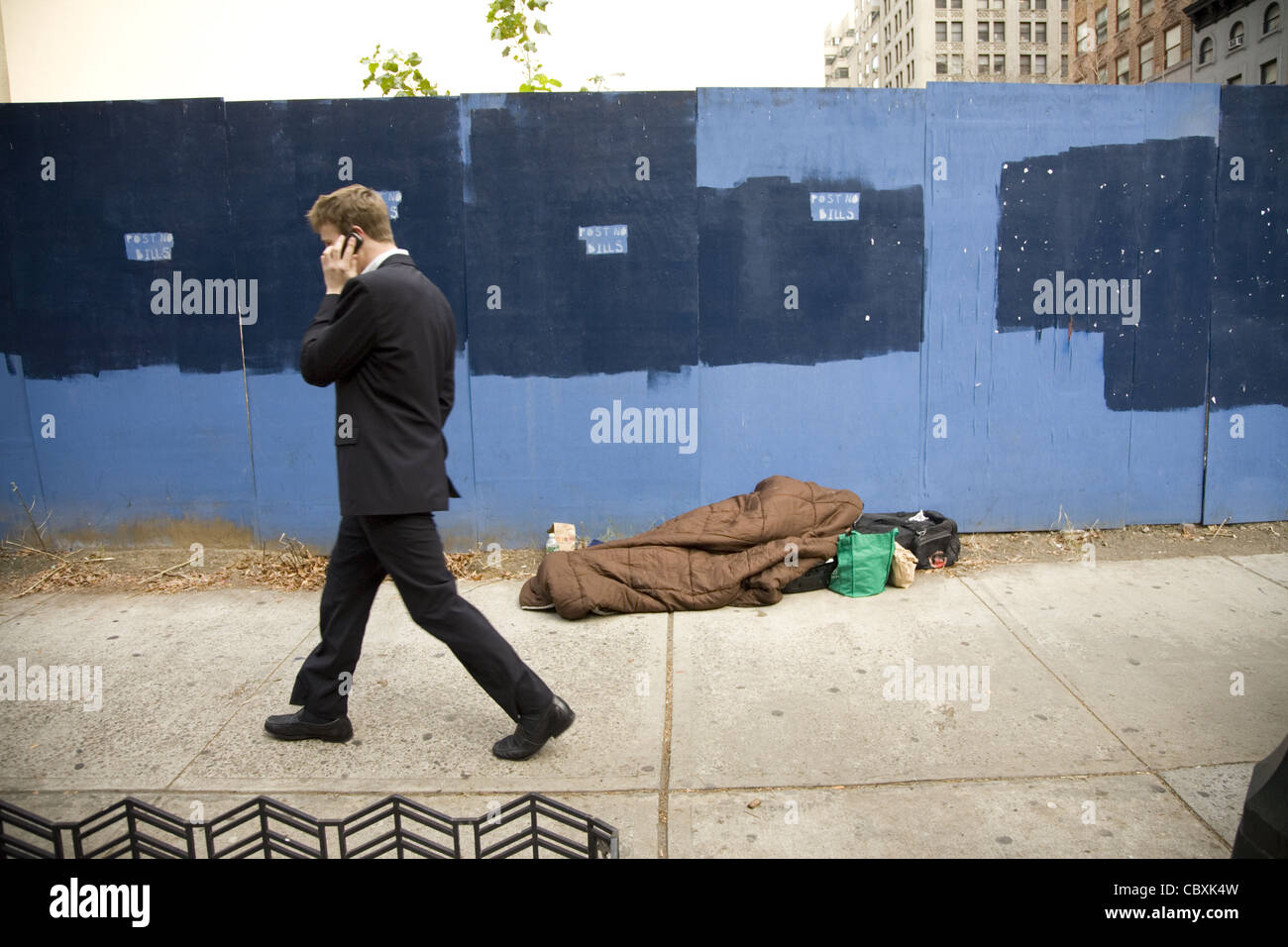 La persona senza dimora addormentato sul marciapiede in midtown Manhattan. Foto Stock