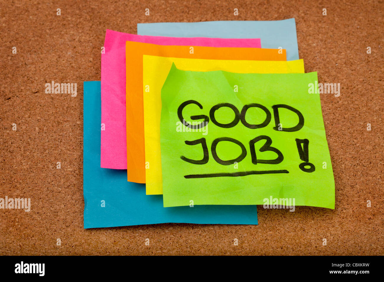 Buon lavoro - congratulazioni, una pila di coloratissimi sticky notes sul sughero bulletin board Foto Stock