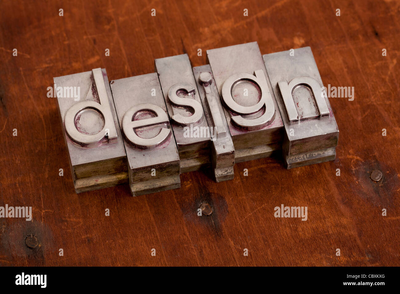 Design - word in metallo vintage tipografia blocca contro grunge sfondo di legno Foto Stock