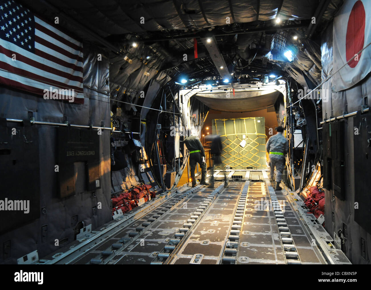 I membri del 36esimo Squadron Airlift e del 730esimo Squadron Air Mobility guidano un pallet nel vano di carico di un C-130 Hercules durante la fase i dell'esercizio Beverly Morning 09-03 Marzo 31 alla base aerea di Yokota, Giappone. Il personale di base effettuerà l'esercizio dal 30 marzo al 3 aprile per mantenere la disponibilità operativa. Foto Stock