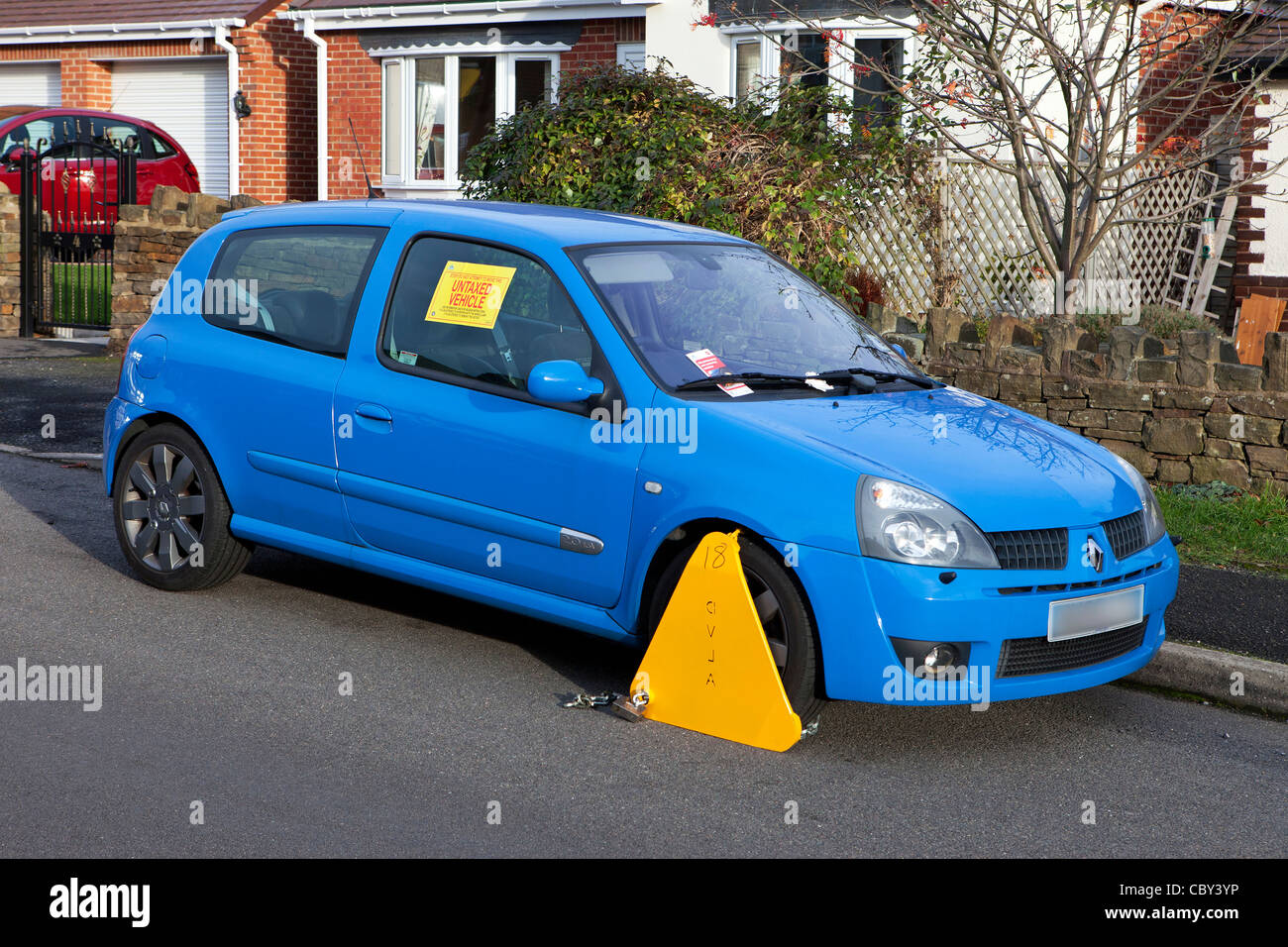 Permessi non tassati veicolo con DVLA a morsetto di bloccaggio di ruota su una strada del Regno Unito Foto Stock