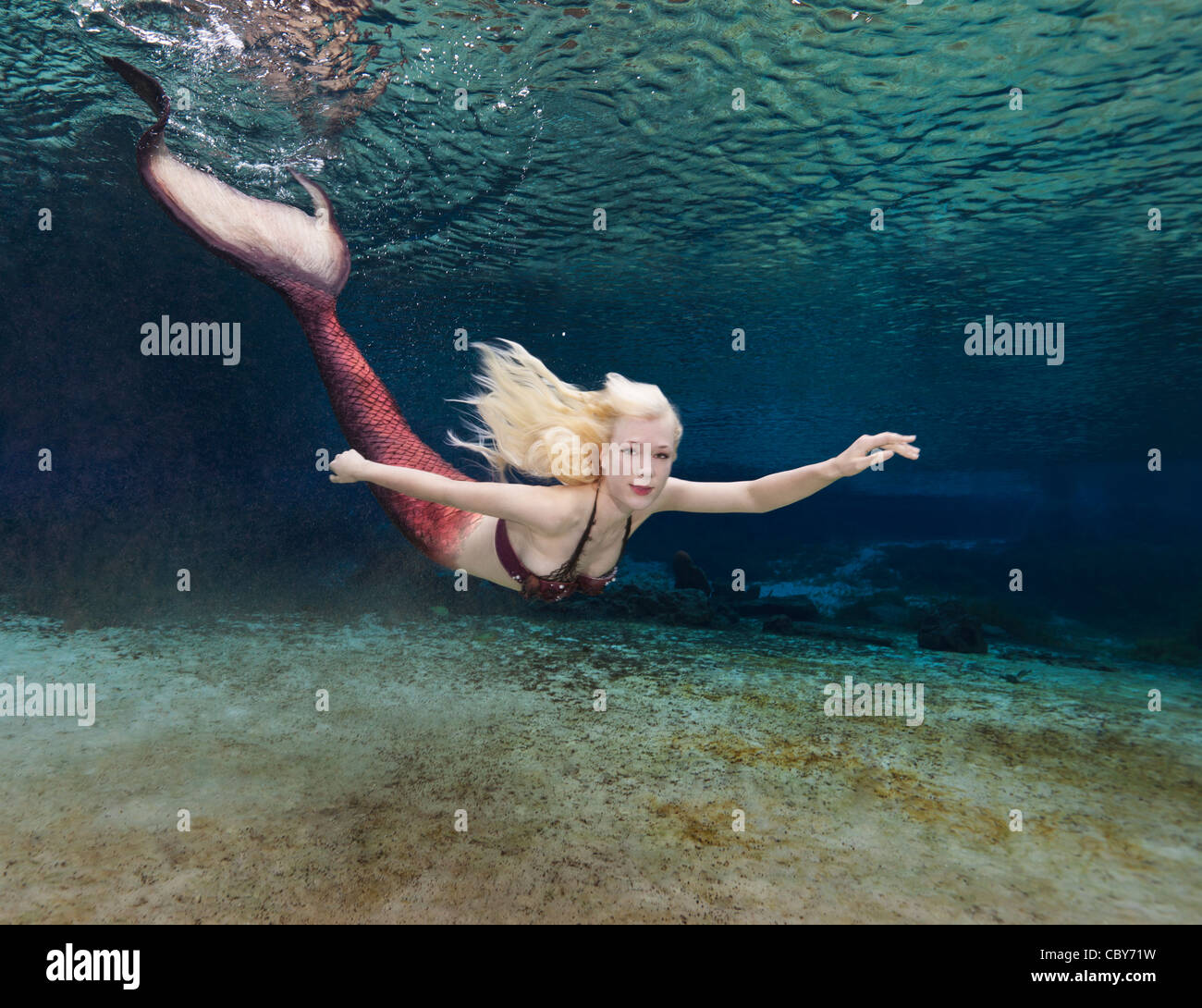 Mermaid nuotare nel fiume arcobaleno Foto Stock