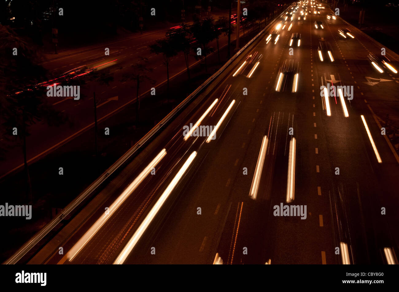 Le vetture si muovono su strade trafficate di notte. Foto Stock