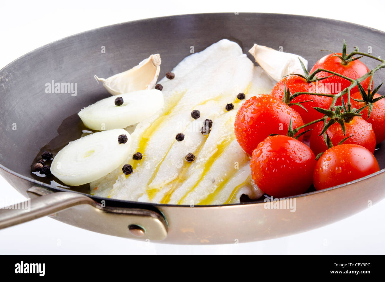 La Passera di mare in una pentola di rame con pomodoro e cipolla Foto Stock
