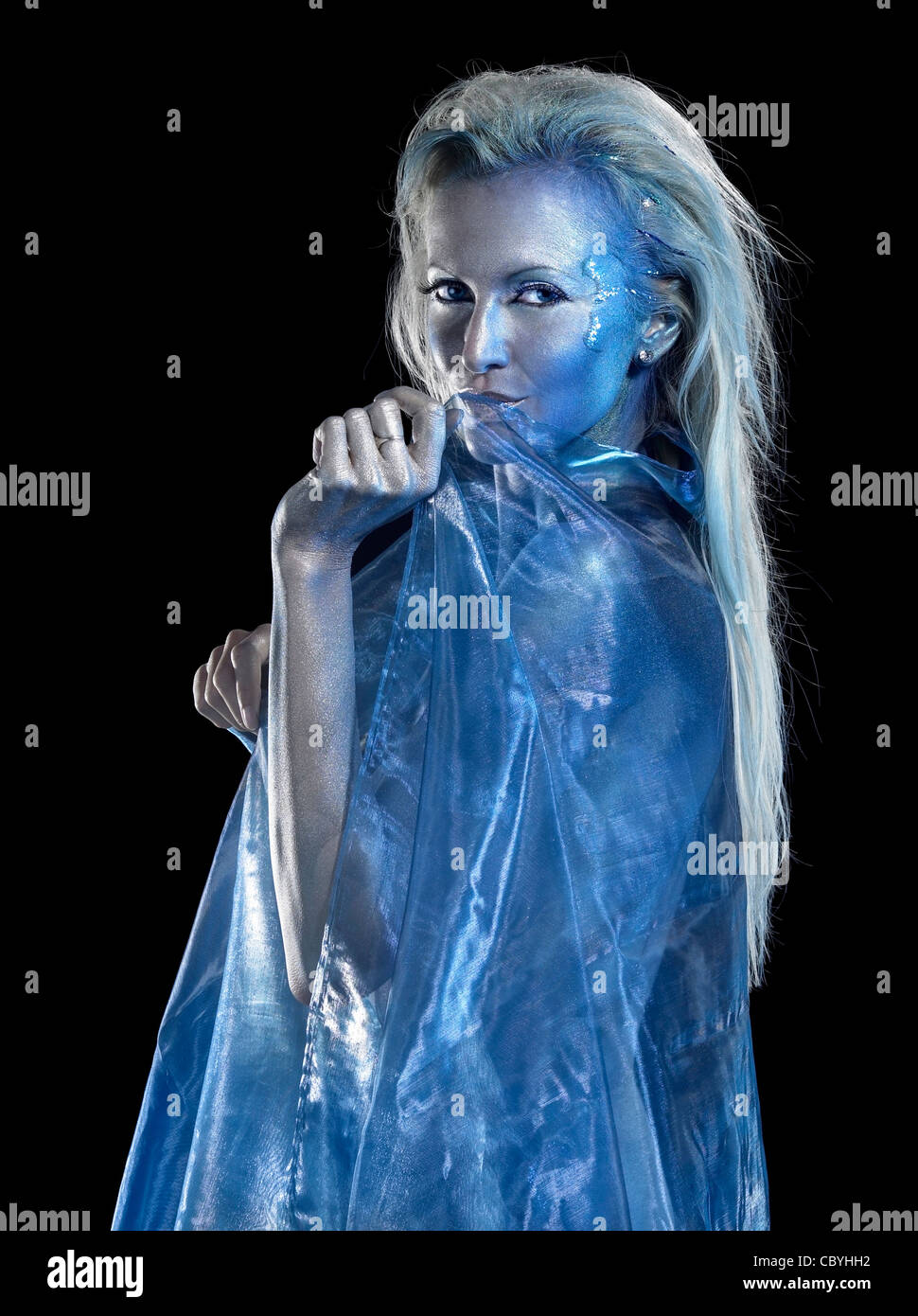 Mystic mermaid tema che mostra una bionda bodypainted Donna rivestita con traslucido tessuti di colore blu, studio di fotografia in black back Foto Stock
