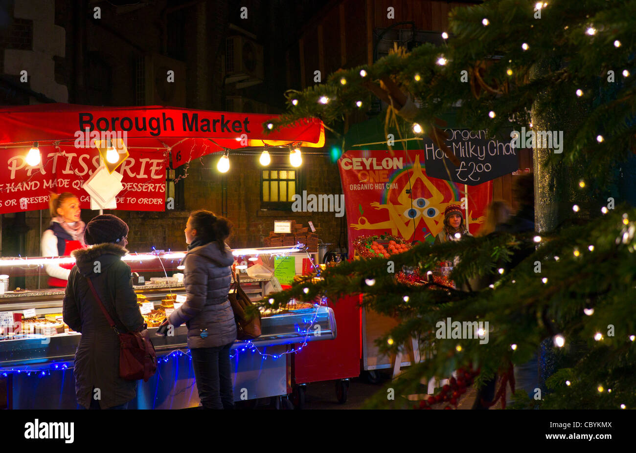 Borough Market pasticceria in stallo visualizzati tramite albero di Natale luci al crepuscolo Southwark Londra Foto Stock