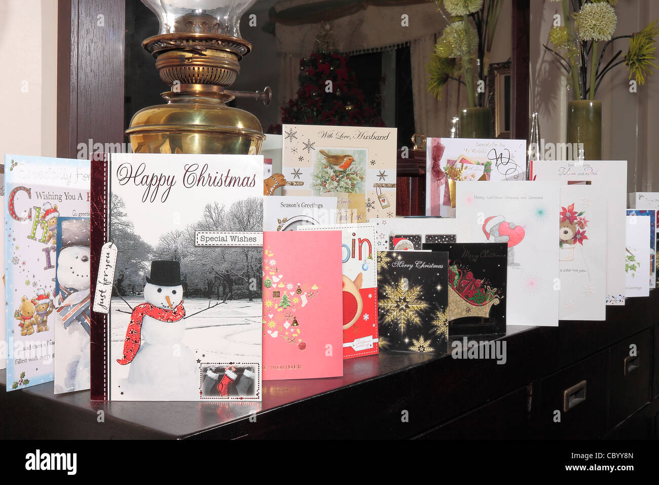 Una linea di carte di Natale su una credenza con uno specchio dietro Foto Stock