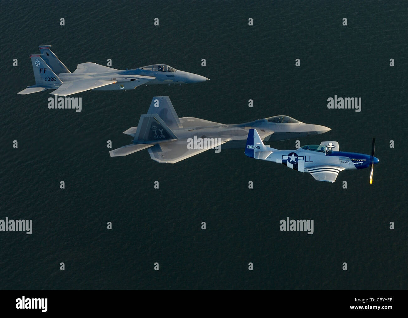SOPRA L'OCEANO ATLANTICO (AFPN) - un F-15 Eagle, F/A-22 Raptor e P-51 Mustang treno per la formazione di volo di eredità che vola il 27 aprile al largo della costa della base dell'aeronautica di Langley, la Va. Maj. Michael doccia, pilotando il F/A-22, Sta ottenendo il suo giro di cassa per la formazione con il pilota di P-51 Gen. Mike DeCuir, il direttore operativo del comando di combattimento dell'aria e il capitano Jason Costello, un pilota del team di dimostrazione della 1° ala del caccia. Foto Stock