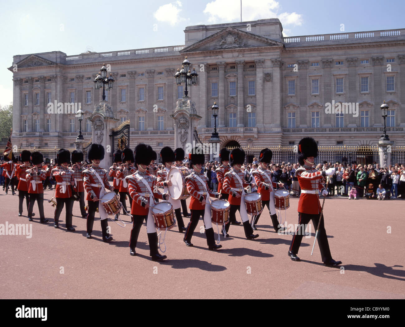 Folle di persone alla cerimonia di cambio guardia reggimento guardie britanniche Musicisti che marciano in uniforme cerimoniale a Buckingham Palace Londra Inghilterra REGNO UNITO Foto Stock
