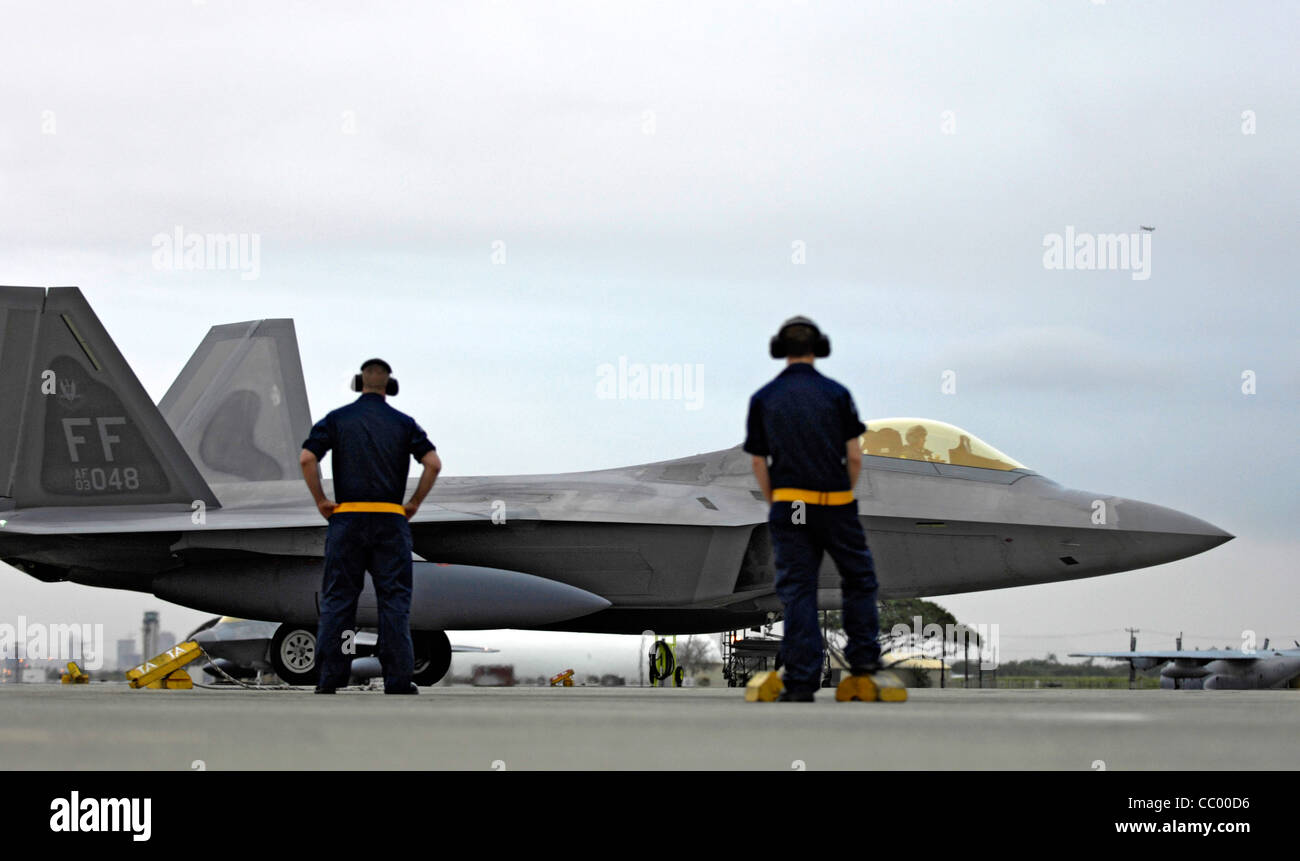 Due capi dell'equipaggio guardano come un F-22 Raptor taxi fino al suo parcheggio il 7 febbraio presso la base dell'aeronautica di Hickam, Hawaii. Gli F-22 e più di 250 Airmen del 27° Fighter Squadron alla base dell'aeronautica di Langley, Virginia, sono diretti alla base aerea di Kadena, Giappone, per il primo schieramento operativo all'estero dell'aeromobile. Foto Stock