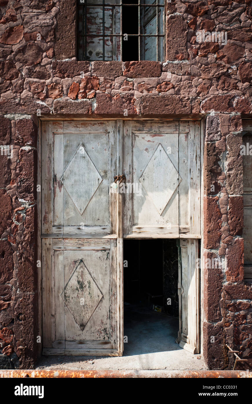 Sbiadita porte dipinte su vecchie warehoue dal porto di Oia - Santorini Foto Stock