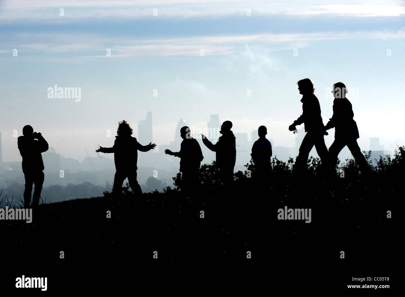 Una rara e una fitta nebbia scende su Londra persone andare su business su Hamstead Heath un gruppo di giovani pratica mosse di danza Foto Stock