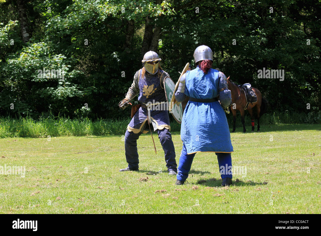 Due cavalieri battaglia con spade e scudi in questo Australian rievocazione di vita medievale in Inghilterra. Foto Stock