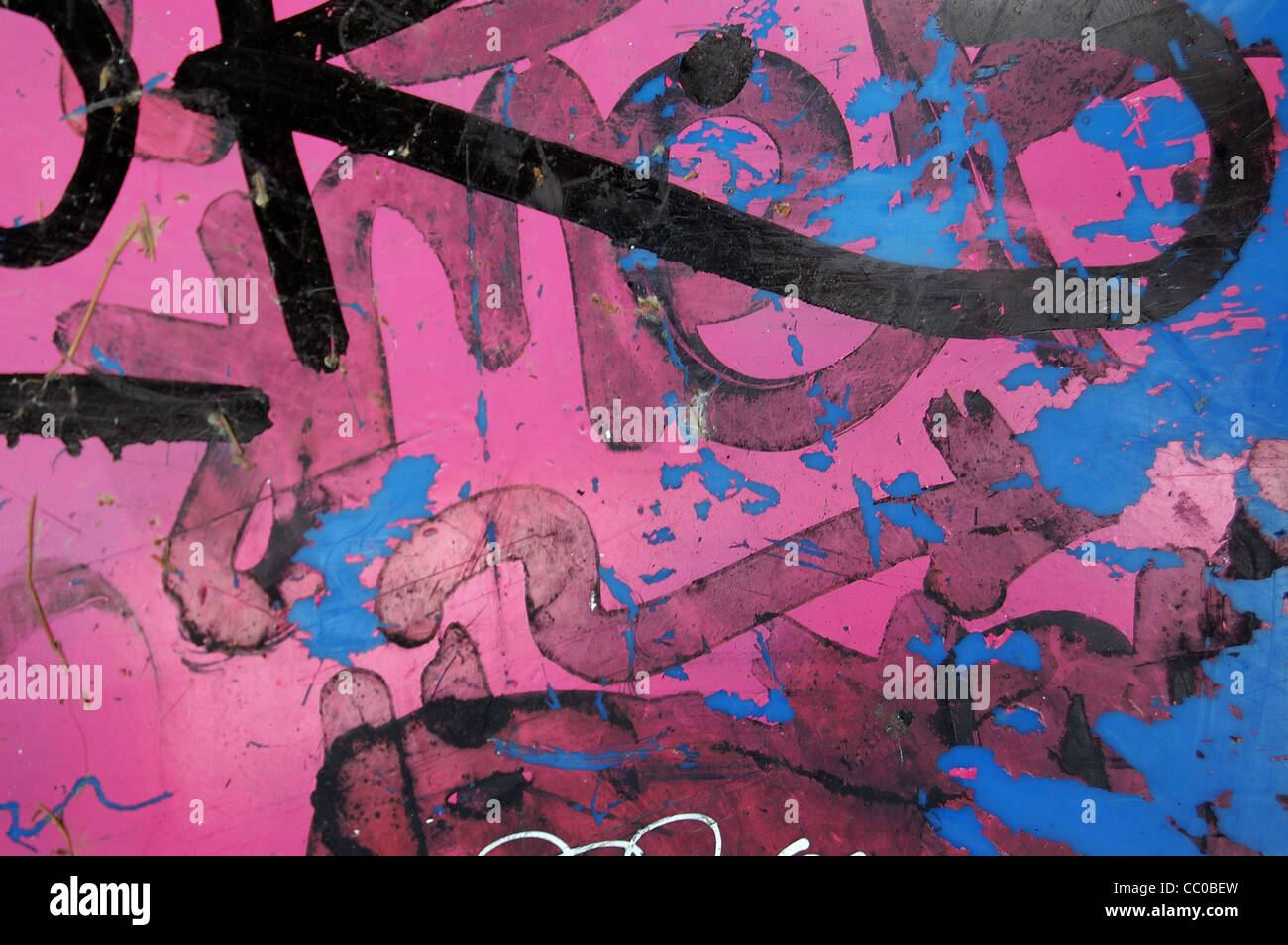 Una superficie di materia plastica ricoperta di graffiti disordinato e peeling sfondo di vernice. Foto Stock
