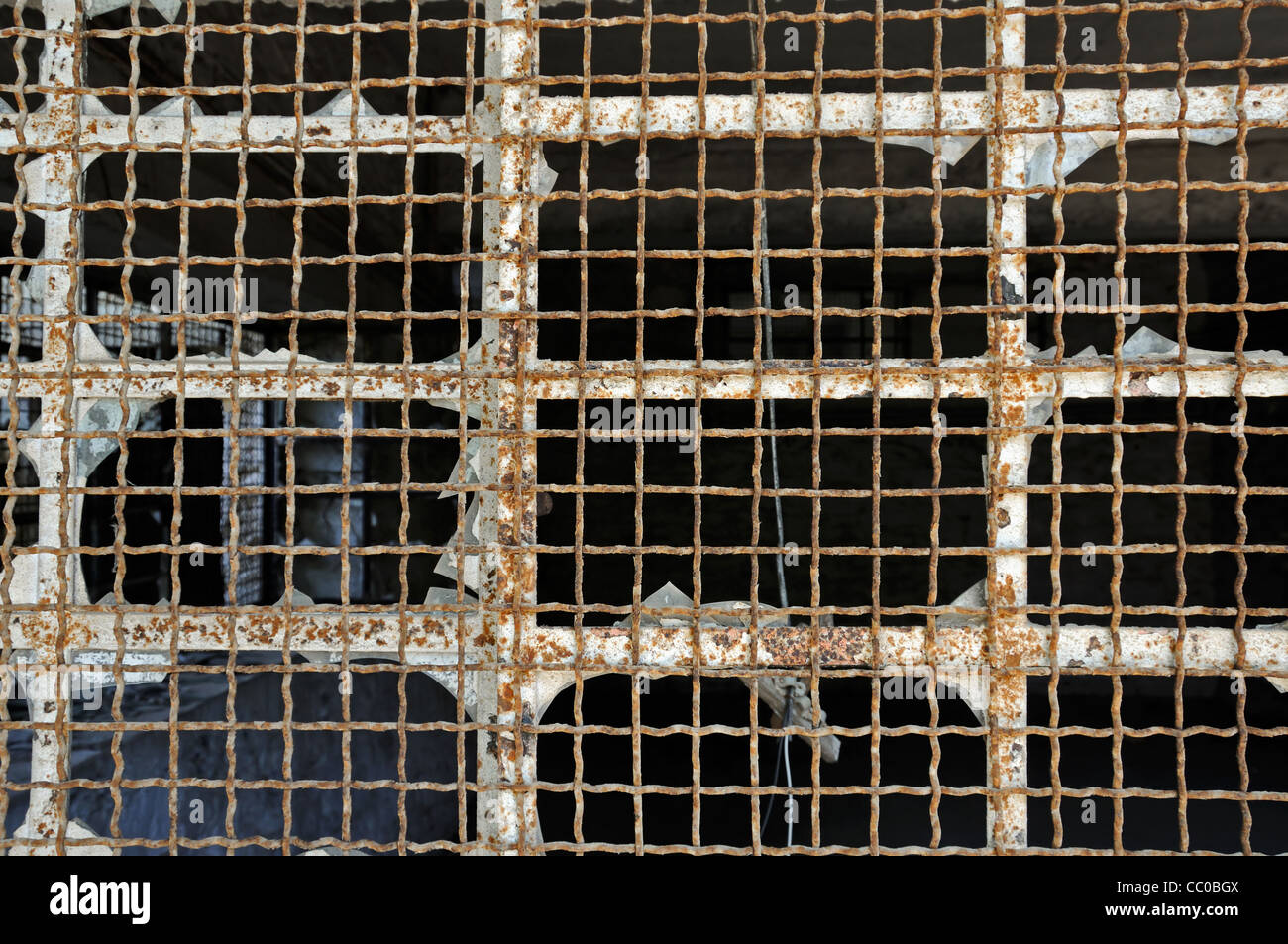 Rottura vetro industriale di maglia di filo nel magazzino abbandonato. Metallo arrugginito texture. Foto Stock