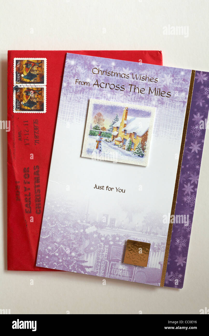 Auguri di Buon Natale da tutta la miglia scheda di natale con busta rossa con timbri da Eire Foto Stock