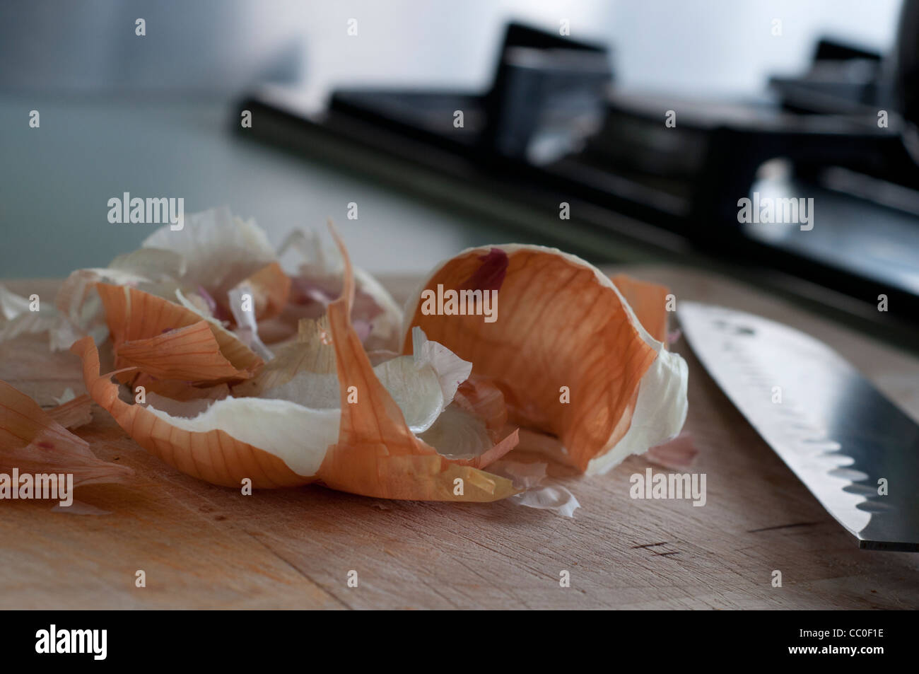 Onion skin e il coltello sul tagliere di legno. Foto Stock