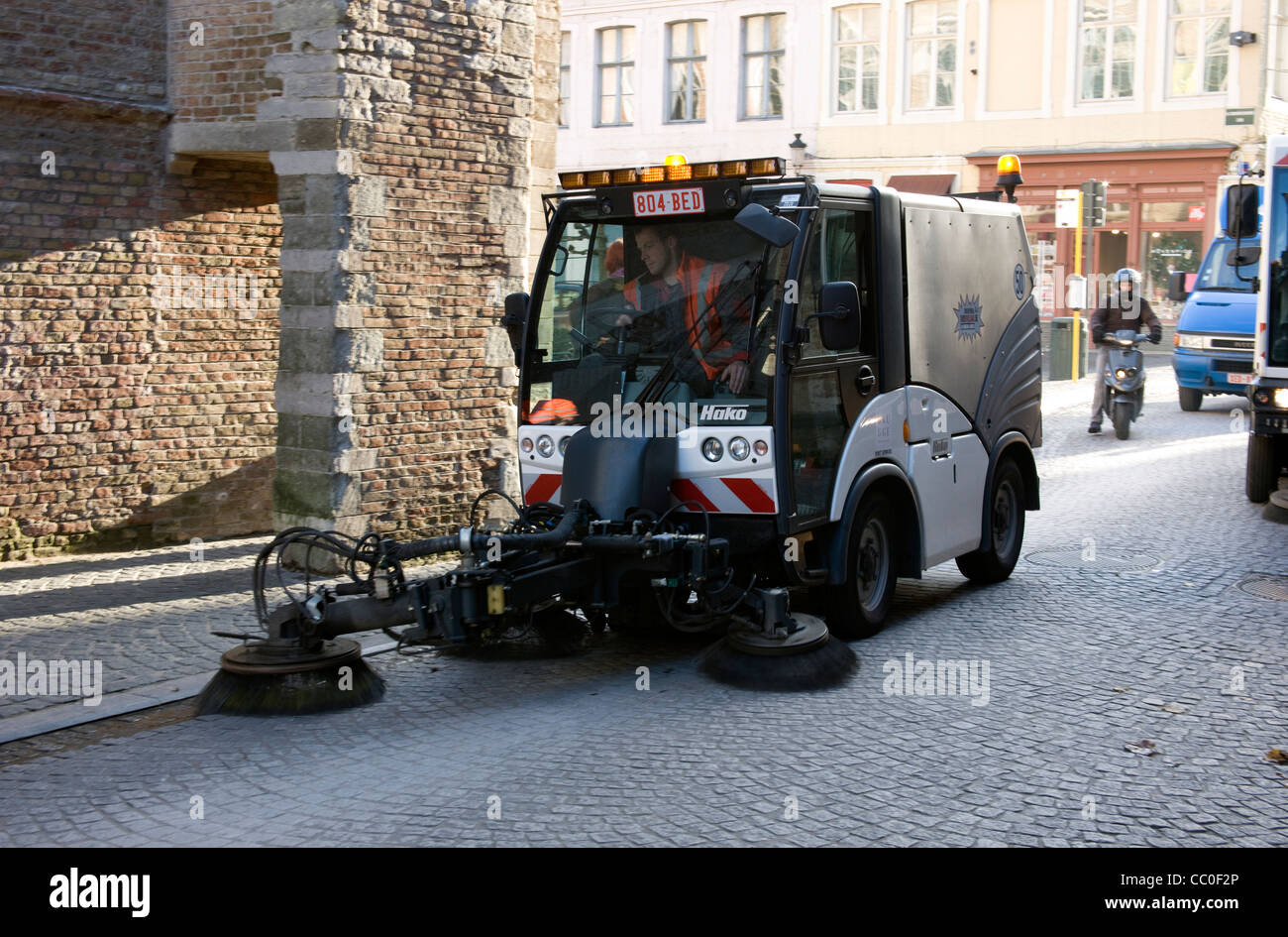 Spazzatrice meccanica essendo usato per spazzare fino cucciolata a Brugge. Foto Stock