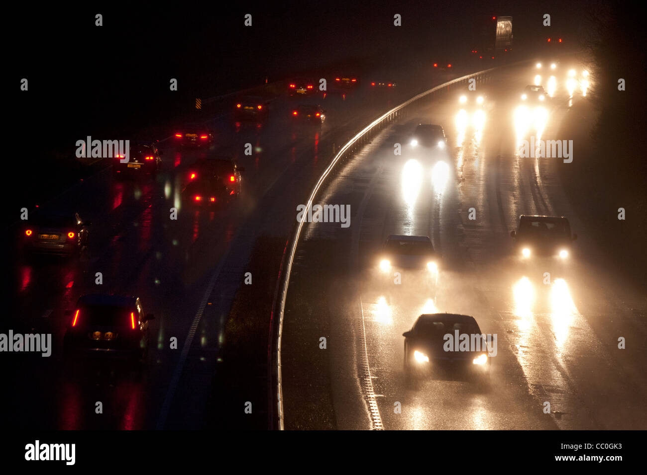 Autovetture e Veicoli di notte su una strada a doppia carreggiata in wet cattiva visibilità pericolose condizioni di pilotaggio, Oxfordshire, Inghilterra Foto Stock