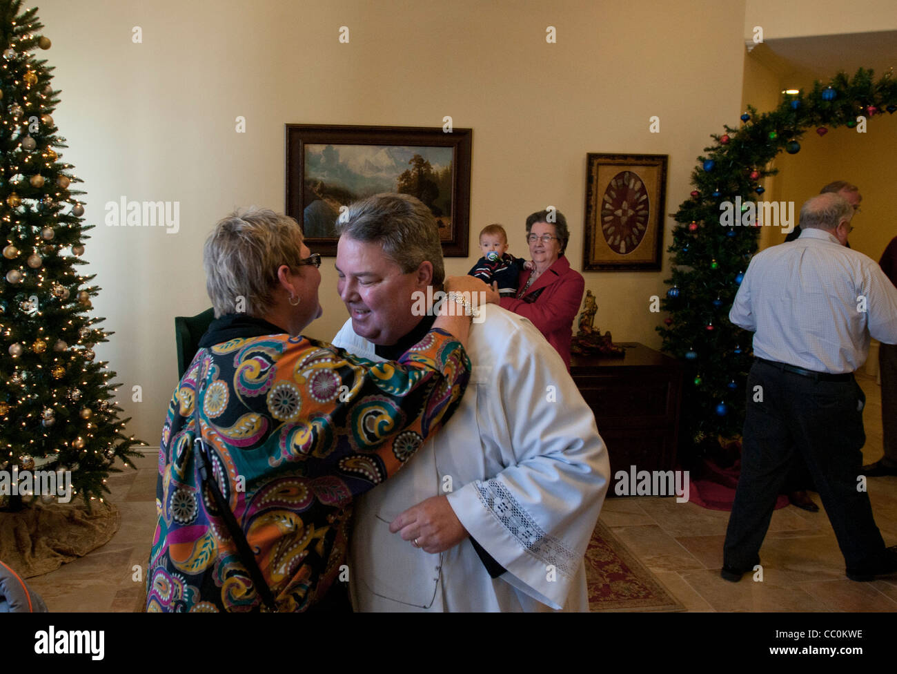 Padre Charles saluta Hough membri della sua congregazione a San Giovanni Maria Vianney nella parrocchia in Cleburne, Tx. Domenica 1 gennaio, 2012. Foto Stock