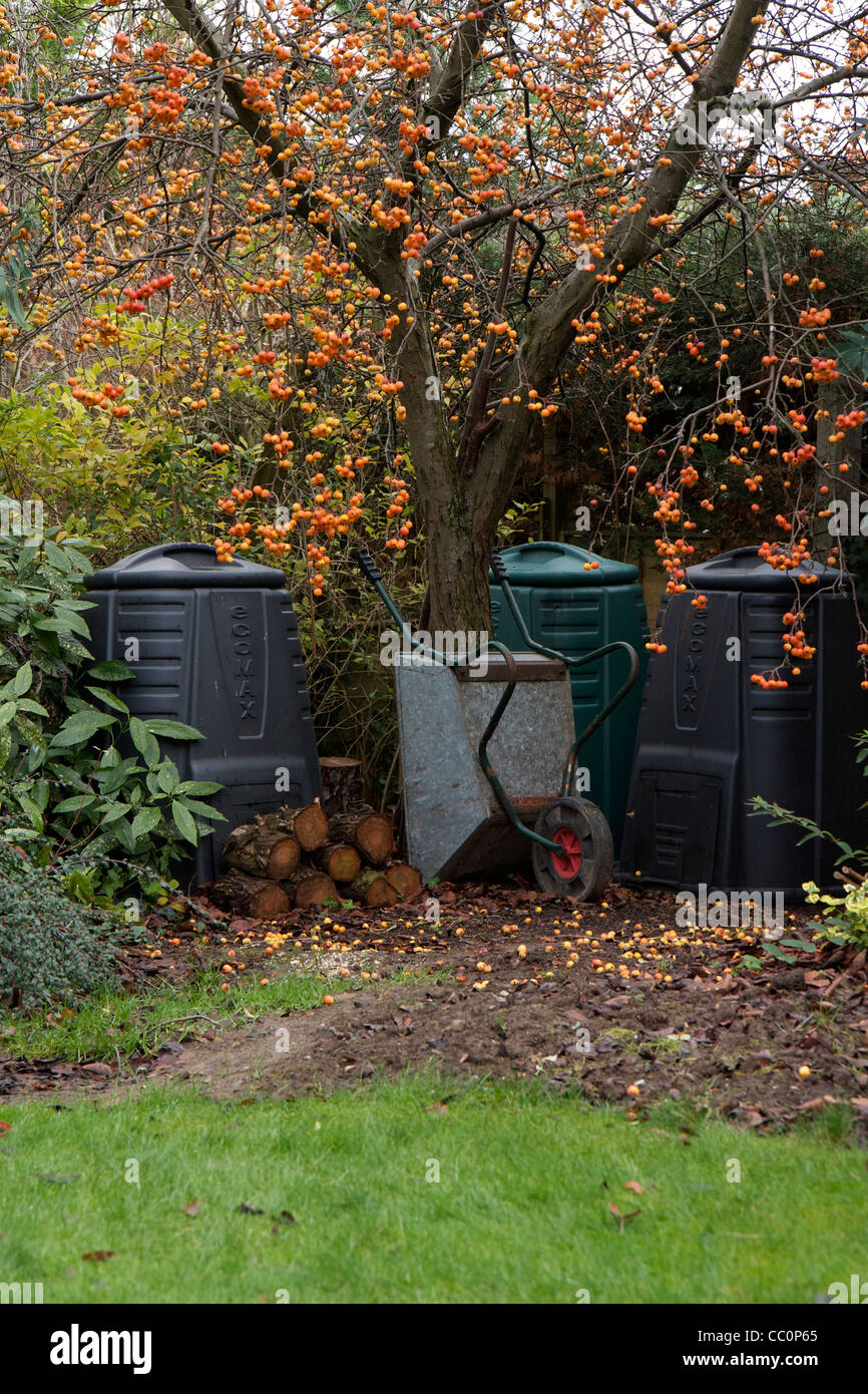 Giardino degli scomparti di compost sotto un granchio melo con tronchi e una ruota di Barrow. Un tipico English country garden scena. Foto Stock