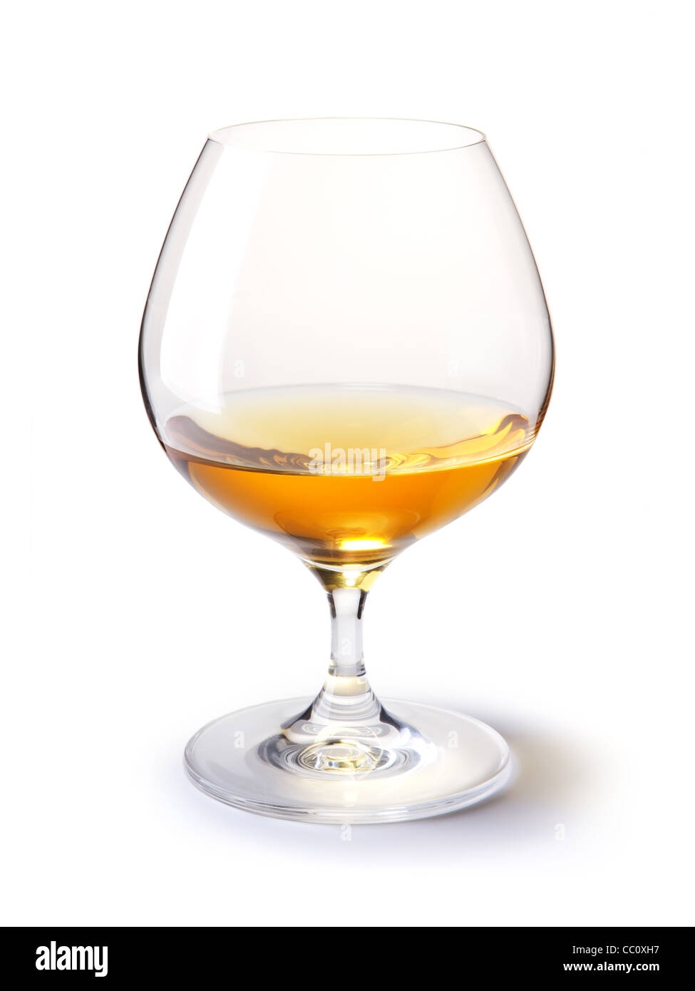 Il cognac di vetro con il cognac oro su un bianco con ombra Foto Stock