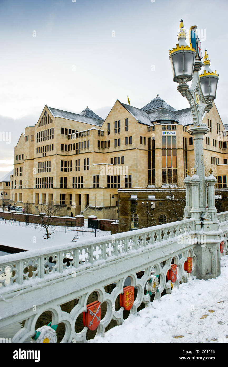 Edificio Aviva dopo la neve pesante visto dal ponte Lendal incorniciata dalle sue luci vittoriane a gas. York. Foto Stock