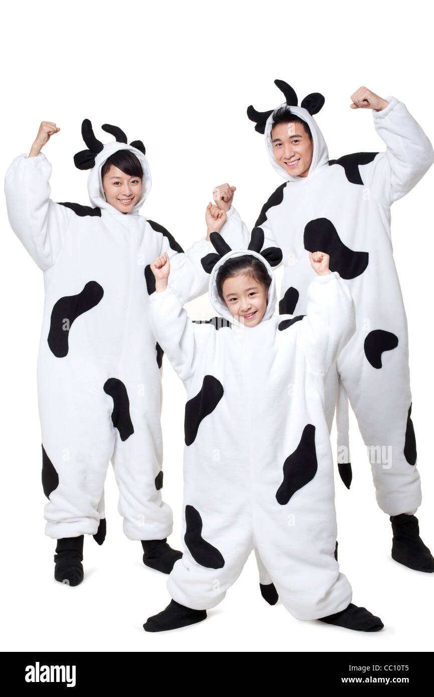 La famiglia in costumi di vacca flettendo i loro muscoli Foto Stock