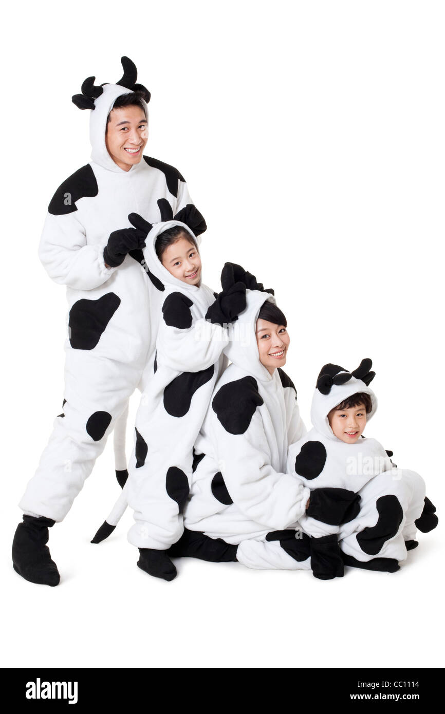 La famiglia in costumi di vacca giocare intorno Foto Stock
