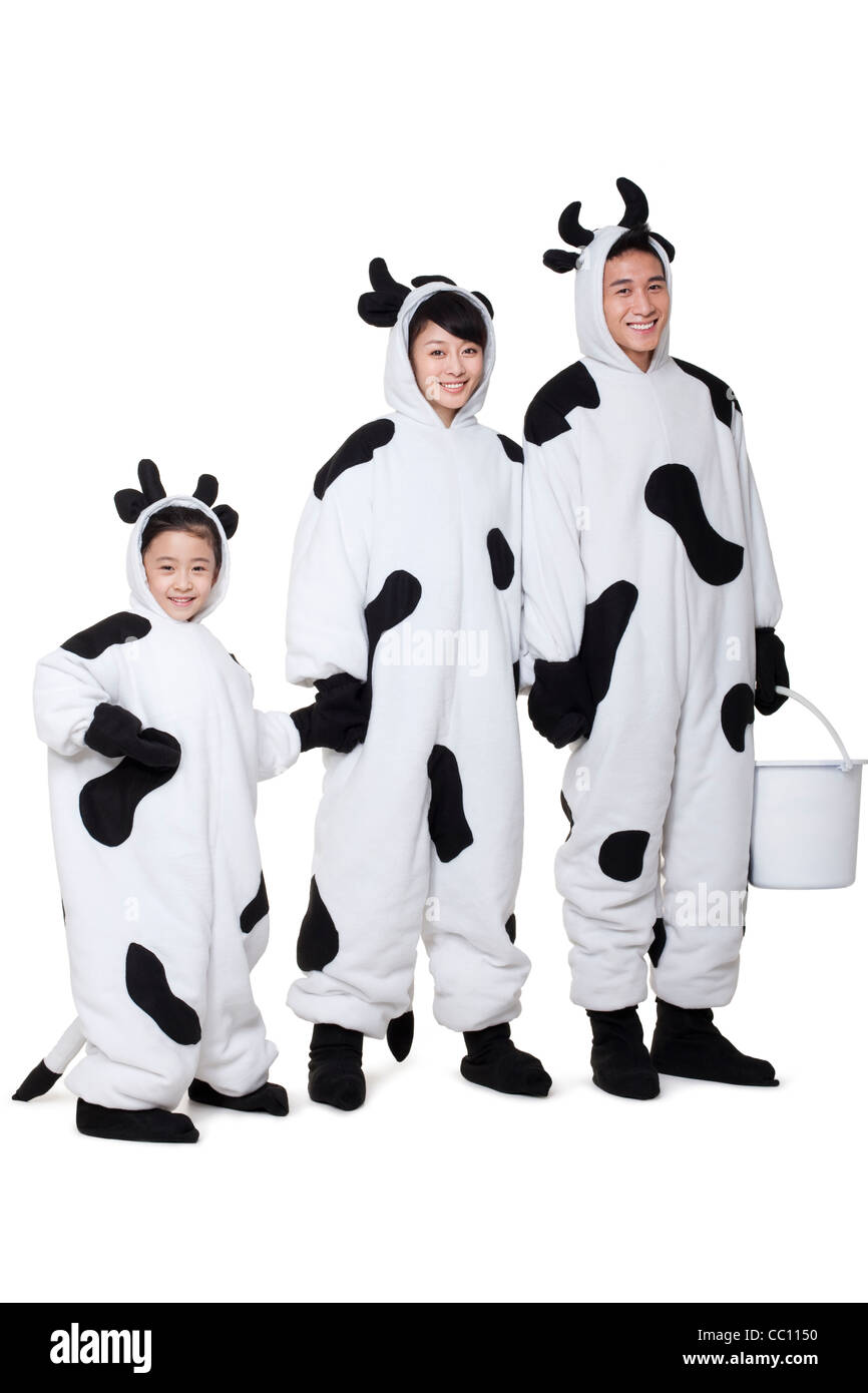 La famiglia in costumi di vacca in una riga Foto Stock