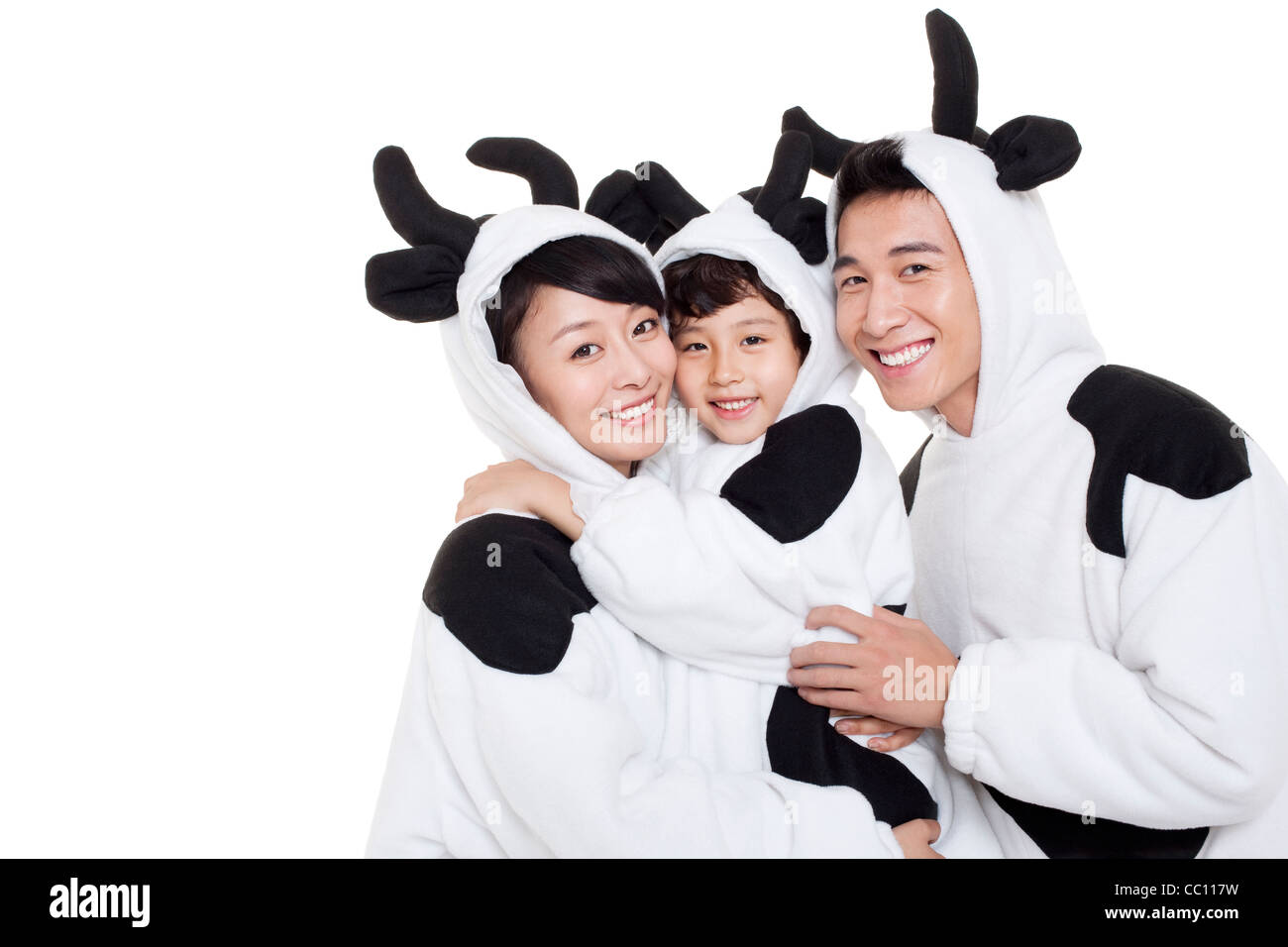 La famiglia in costumi di vacca avvolgente Foto Stock