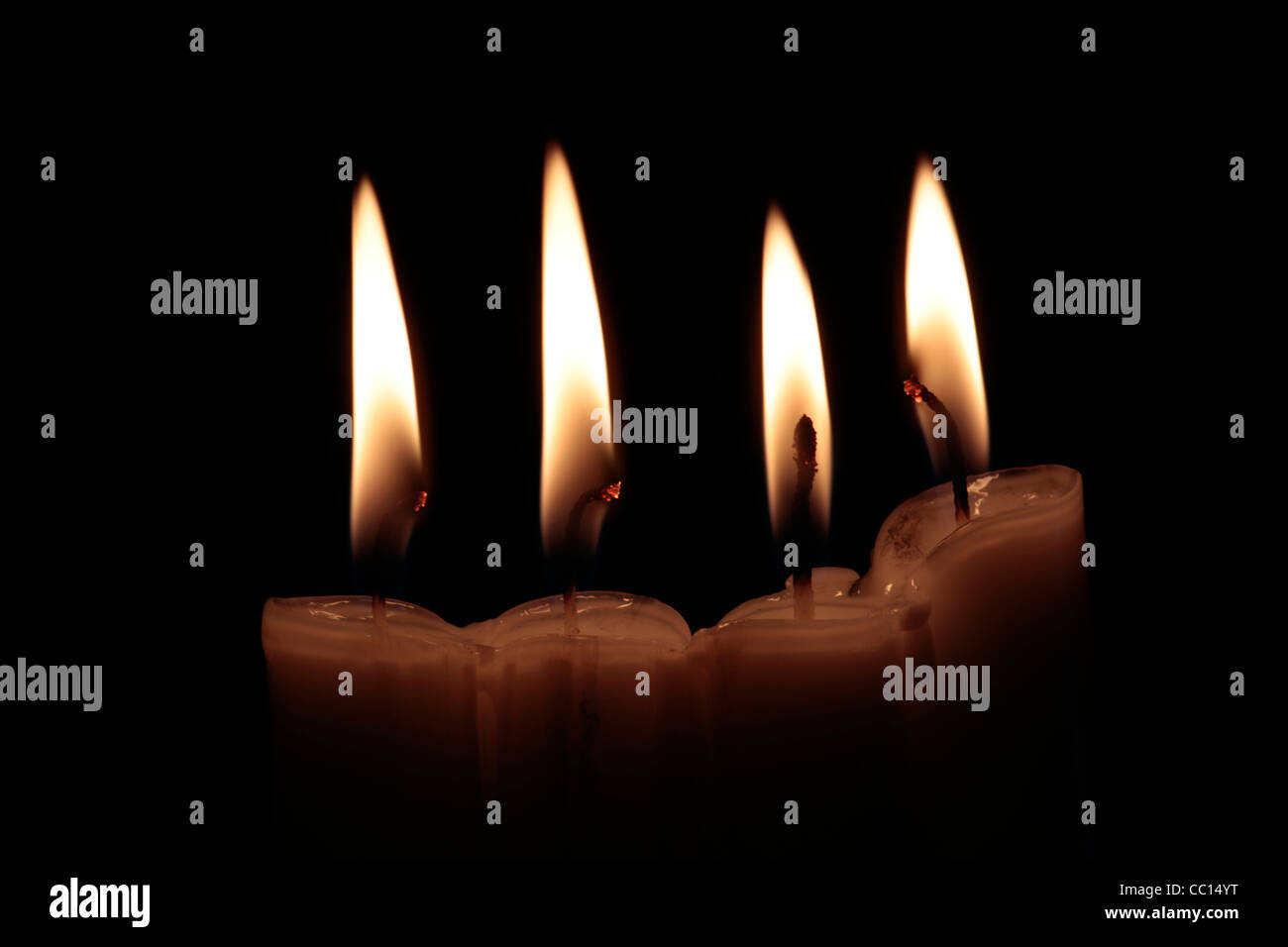 Quattro candele accese su sfondo nero, con incandescente stoppini, inquadratura orizzontale Foto Stock