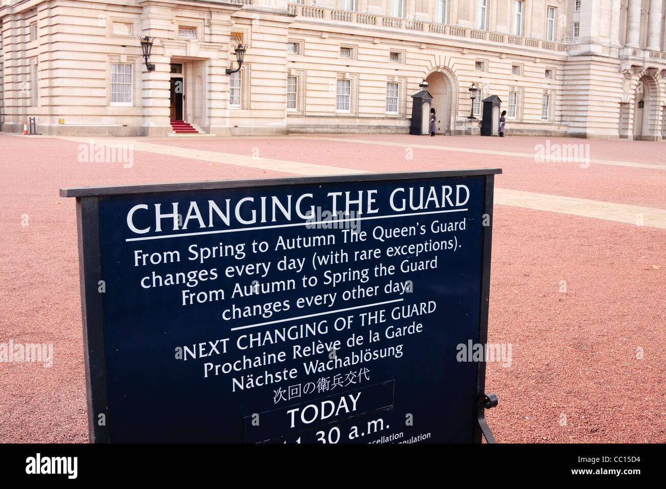 Buckingham Palace, London, Regno Unito - cambiando il segno di protezione sulla parte anteriore con la regina della guardia in background Foto Stock