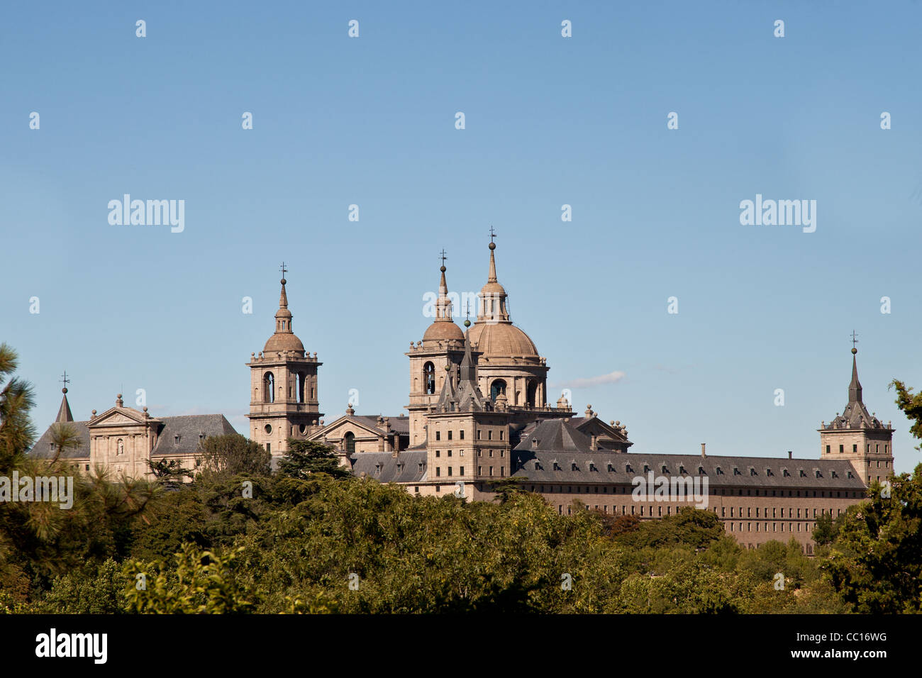 Il monastero di San Lorenzo de El Escorial da Casita del Infante. Le torri della chiesa e il monastero sono set di da un cielo blu Foto Stock